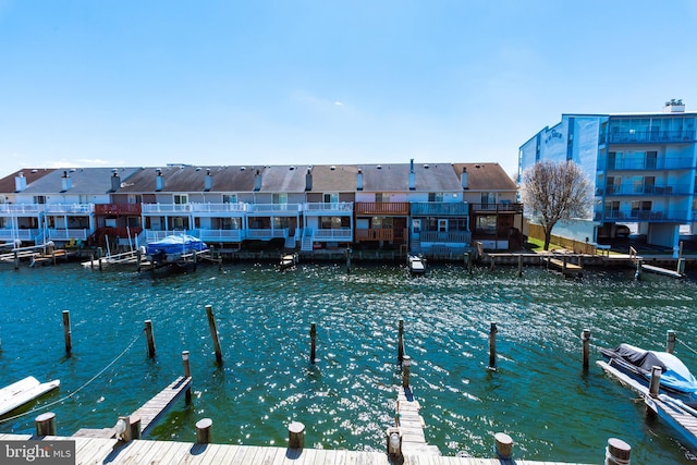 view of dock with a residential view and a water view