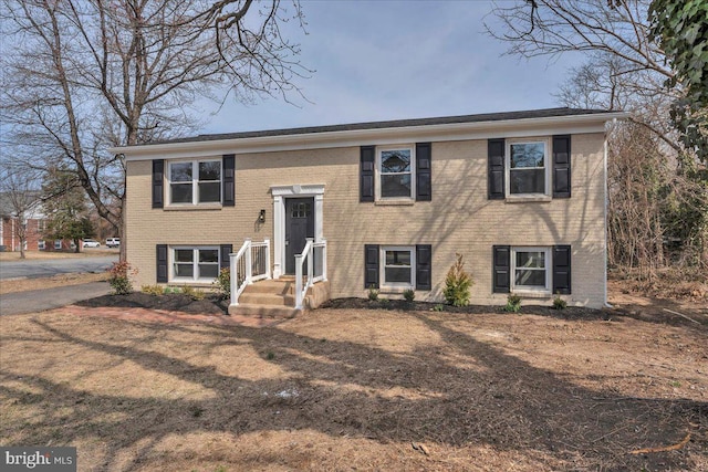 split foyer home featuring brick siding