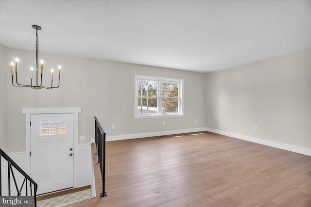 foyer with an inviting chandelier, baseboards, and wood finished floors