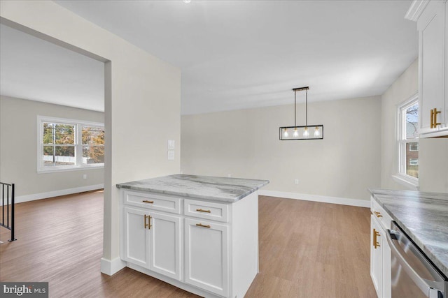 kitchen featuring a wealth of natural light, white cabinets, light wood-type flooring, and stainless steel dishwasher