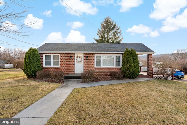 single story home with brick siding, a front yard, and a shingled roof