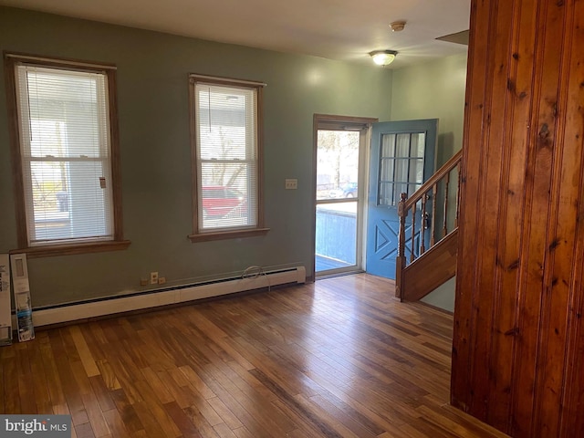 foyer entrance with a baseboard radiator, stairs, and hardwood / wood-style flooring