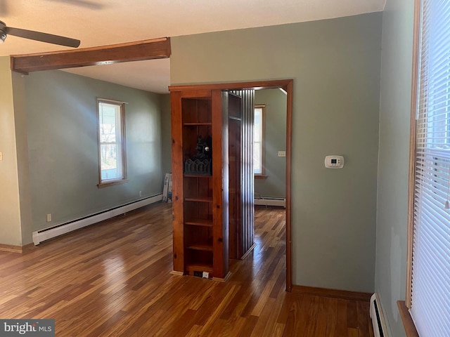 hallway featuring baseboard heating, a baseboard heating unit, and wood finished floors