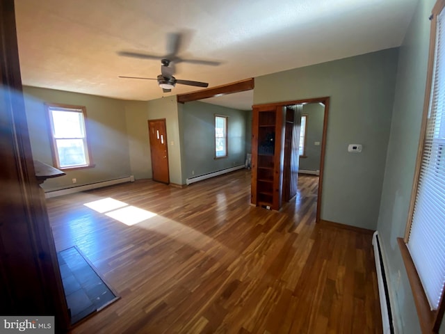 spare room with wood finished floors, baseboards, and a baseboard radiator