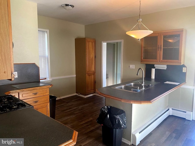 kitchen featuring a sink, dark countertops, and a peninsula