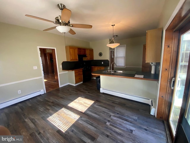 kitchen with baseboard heating, dark countertops, a peninsula, and dark wood-style flooring