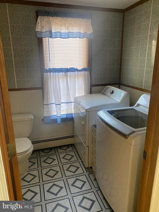 laundry area with washer and clothes dryer, baseboard heating, wainscoting, and laundry area