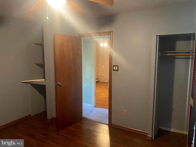 unfurnished bedroom featuring a closet, baseboards, and wood finished floors