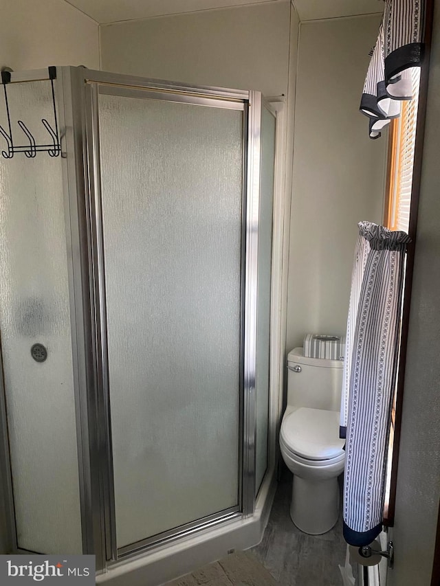 full bath with toilet and a stall shower