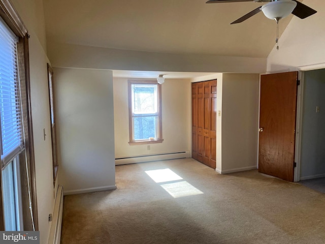 unfurnished bedroom featuring vaulted ceiling, carpet floors, and a baseboard radiator