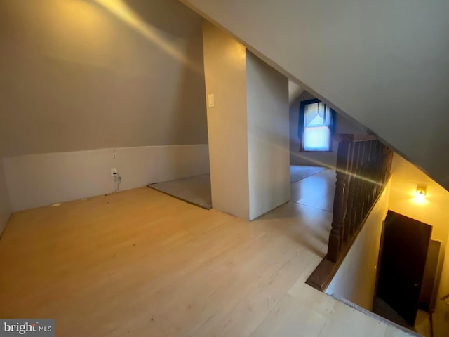 additional living space featuring wood finished floors and vaulted ceiling