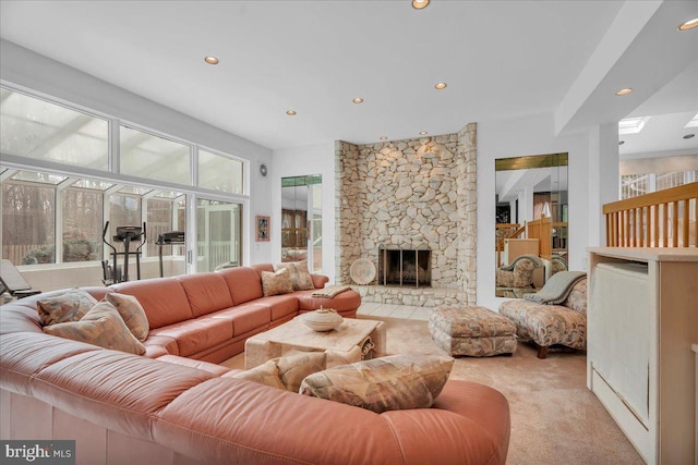 living area featuring recessed lighting, a stone fireplace, and light colored carpet