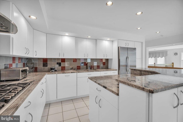 kitchen with light tile patterned floors, decorative backsplash, recessed lighting, stainless steel appliances, and a sink