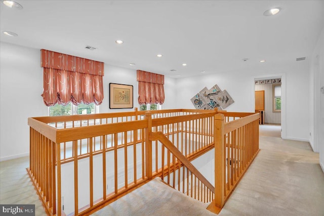 hallway with an upstairs landing, visible vents, recessed lighting, and baseboards