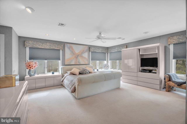 bedroom featuring visible vents, multiple windows, carpet, and ceiling fan