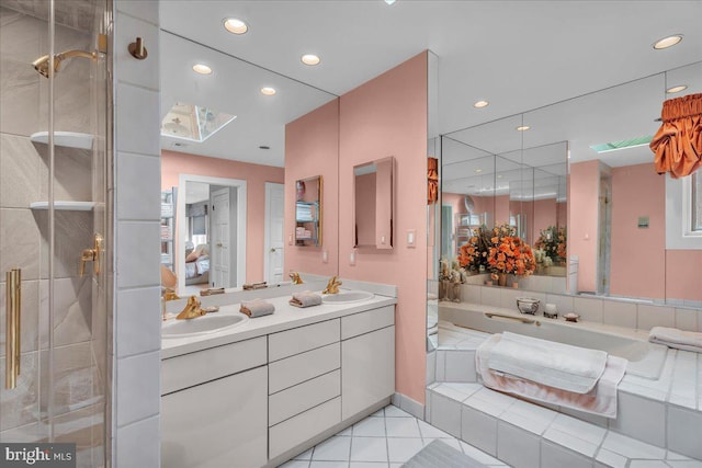 ensuite bathroom with tile patterned floors, a shower stall, ensuite bath, and a sink