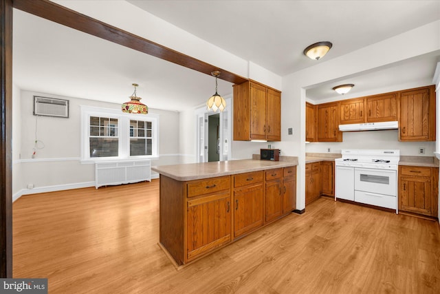 kitchen featuring brown cabinets, under cabinet range hood, radiator heating unit, a peninsula, and white range with gas stovetop