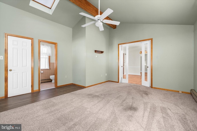 unfurnished bedroom featuring high vaulted ceiling, ensuite bathroom, carpet, a skylight, and baseboard heating