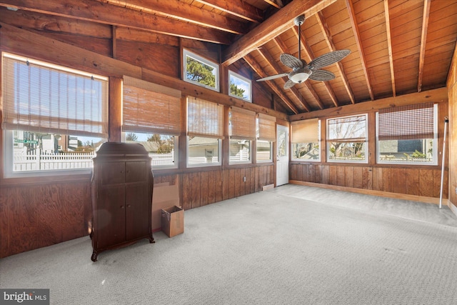 unfurnished sunroom with a wealth of natural light, a ceiling fan, wood ceiling, and vaulted ceiling with beams