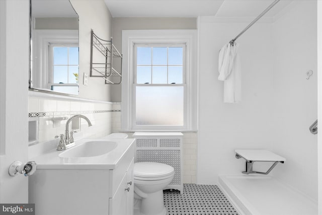 bathroom featuring toilet, vanity, tile walls, and a shower with shower curtain