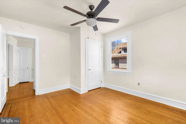 unfurnished bedroom featuring ceiling fan, light wood-type flooring, and baseboards