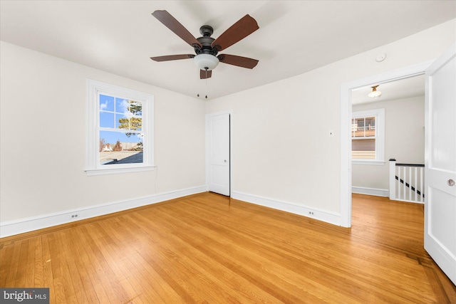 unfurnished room with baseboards, light wood-type flooring, and ceiling fan