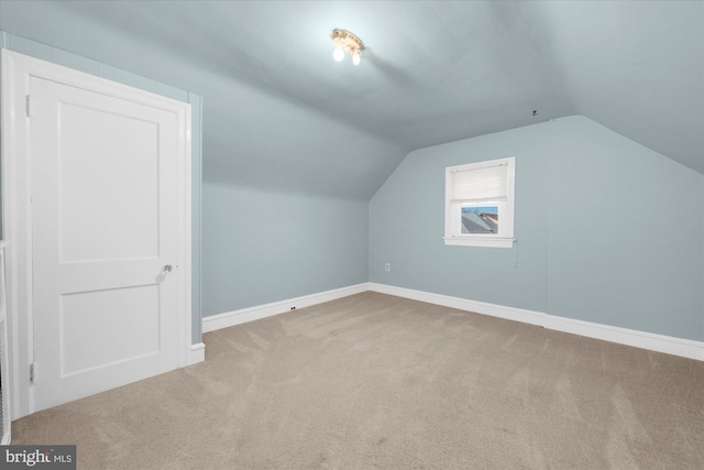 additional living space featuring vaulted ceiling, carpet flooring, and baseboards