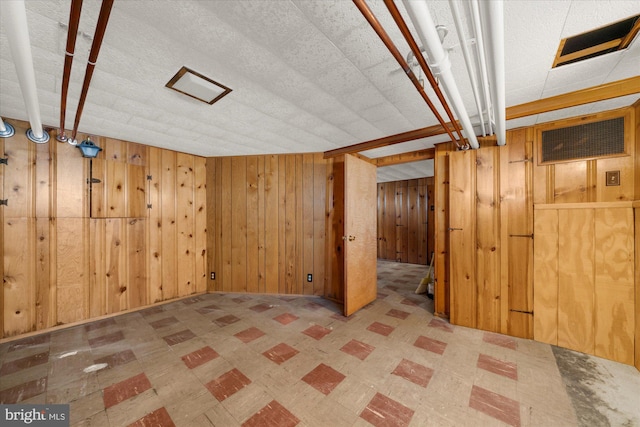 finished below grade area featuring tile patterned floors and wooden walls