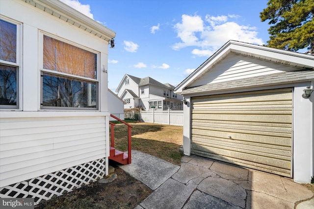 view of yard with a detached garage, an outdoor structure, and fence