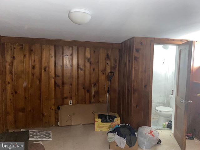 interior space with toilet and wood walls