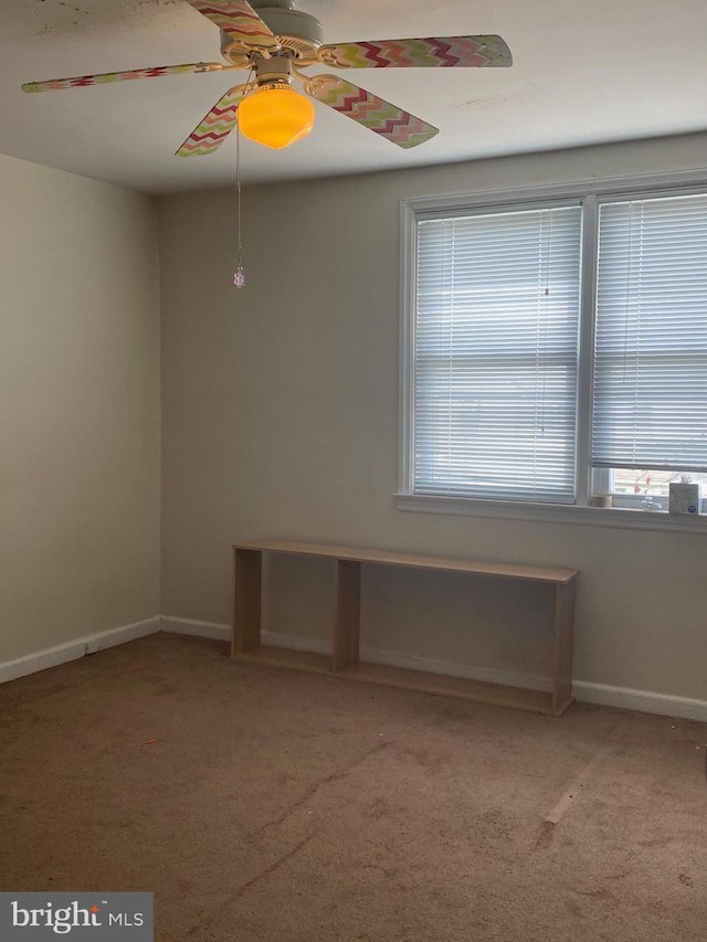 unfurnished room with light carpet, a ceiling fan, and baseboards