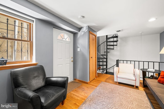 sitting room featuring visible vents, baseboards, stairway, recessed lighting, and wood finished floors