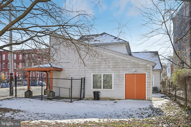 snow covered house with fence