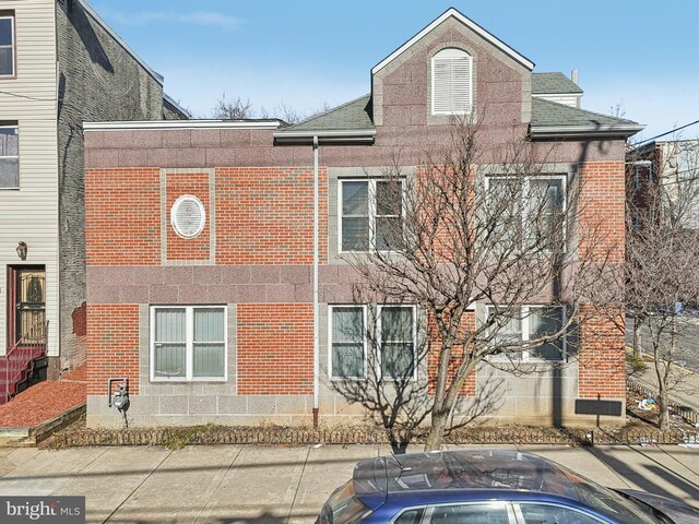 exterior space featuring entry steps, brick siding, and roof with shingles