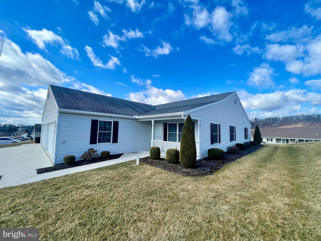 view of front of home with a shingled roof, covered porch, concrete driveway, a front yard, and an attached garage