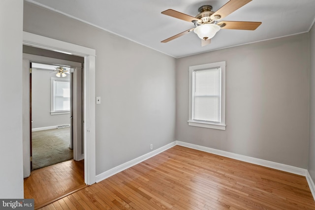 unfurnished room with visible vents, a ceiling fan, baseboards, and light wood finished floors