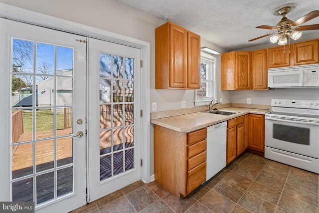 kitchen featuring white appliances, a sink, light countertops, french doors, and a textured ceiling