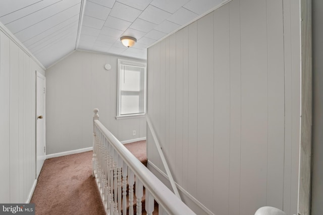 hall featuring an upstairs landing, vaulted ceiling, baseboards, and carpet floors