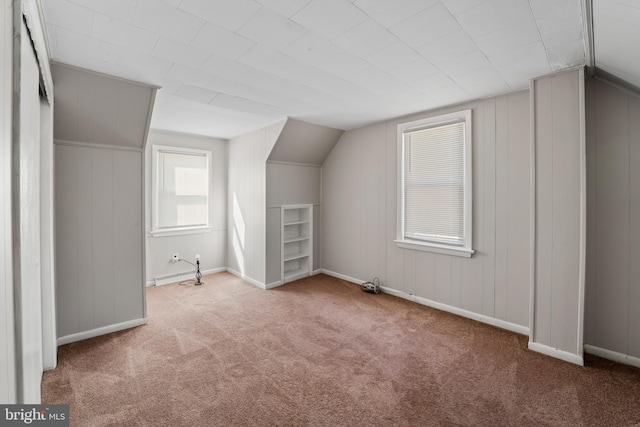 bonus room with baseboards, lofted ceiling, and carpet