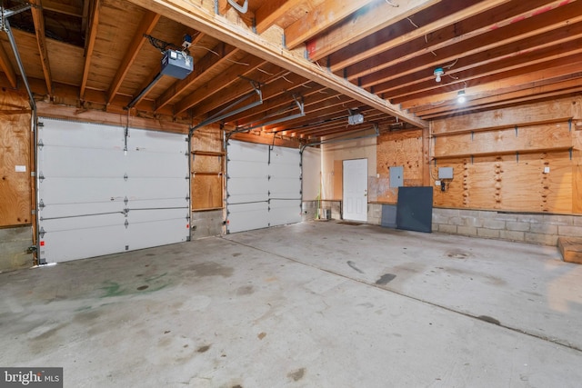 garage with electric panel and a garage door opener