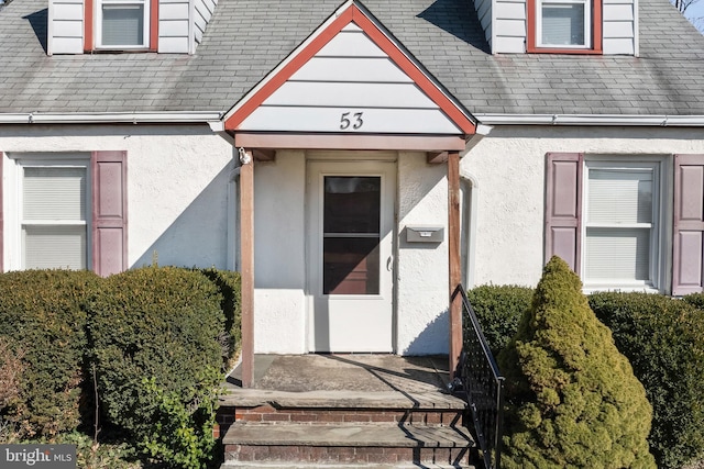 doorway to property featuring stucco siding