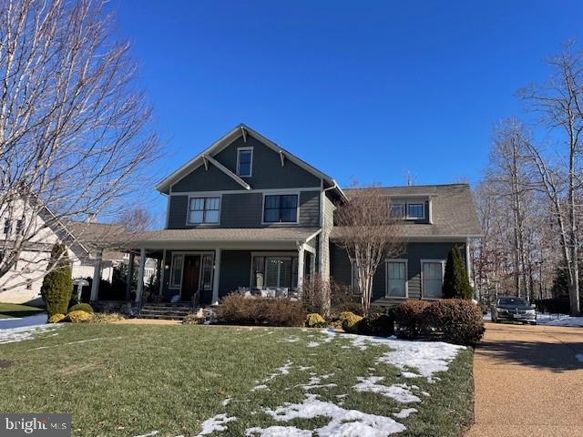 view of front of home featuring covered porch and a front lawn