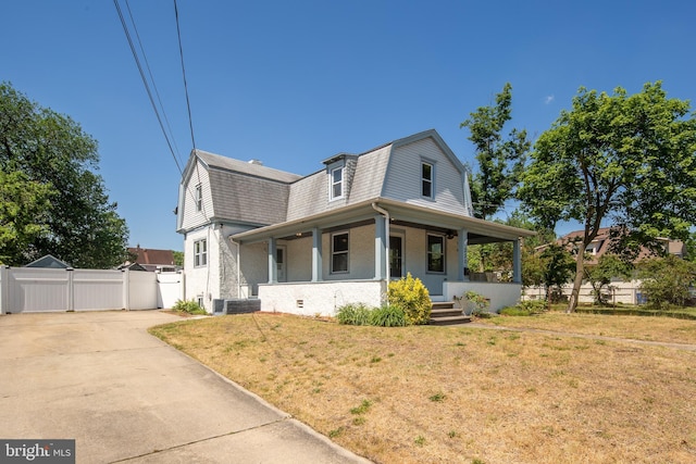 view of front facade featuring a gambrel roof, a front lawn, a gate, a porch, and fence