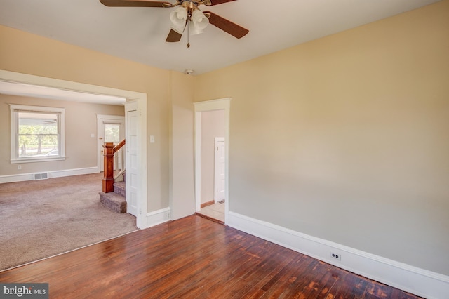 spare room with visible vents, baseboards, wood finished floors, and stairs