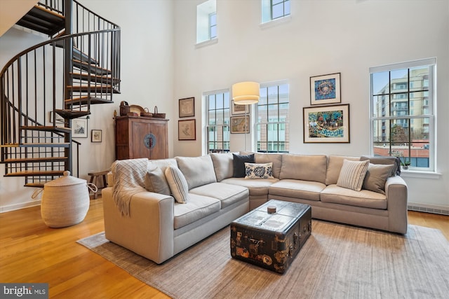 living area featuring stairway, wood finished floors, and visible vents