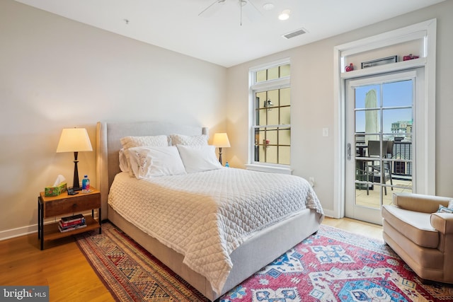 bedroom featuring a ceiling fan, baseboards, visible vents, light wood finished floors, and access to exterior