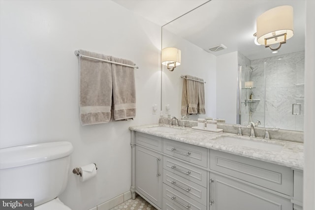 bathroom featuring a shower stall, toilet, visible vents, and a sink