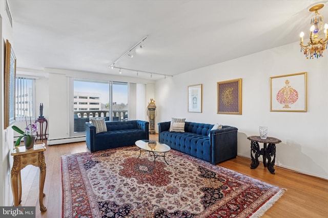 living room with baseboard heating, a healthy amount of sunlight, and wood finished floors