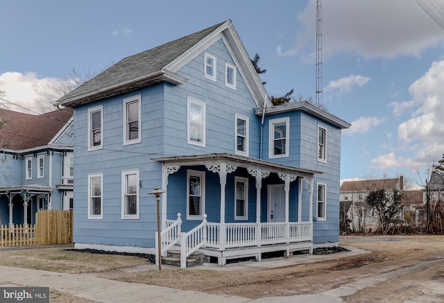 view of front facade featuring covered porch and fence