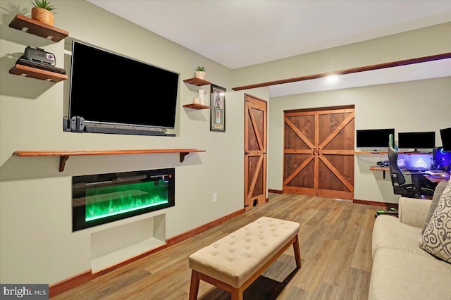 living area with baseboards and wood finished floors